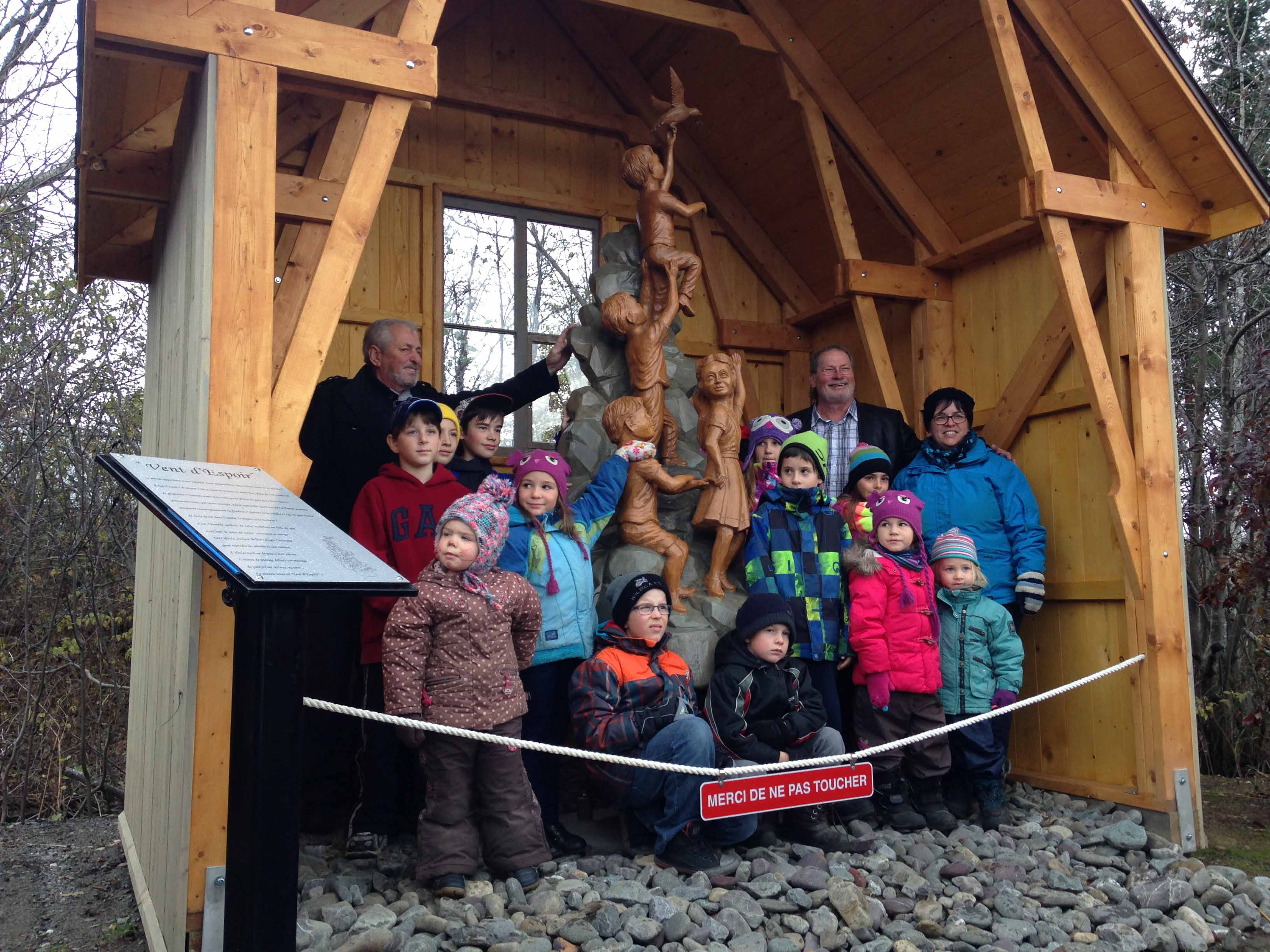 M. Clermont Gagnon entouré d’enfants et accompagné de M. Alphé St-Pierre (maire) et de Mme Isabelle Vaillancourt (enseignante et représentante du comité de la cour d’école) 